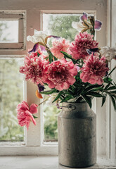 Bouquet of pink peonies on a windowsill