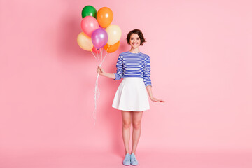 Full size photo of young beautiful smiling cheerful charming girl hold balloons wear mini skirt isolated on pink color background