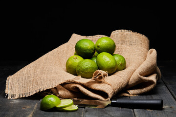 fresh green limes on a brown bag on a table
