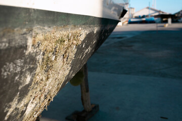 Bottom of sail boat dirty hull lifted on dry docks or shipyard