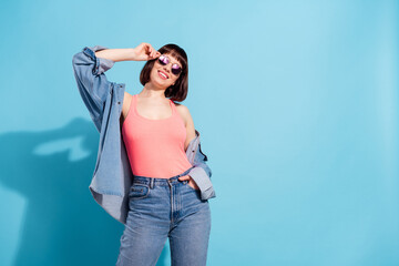 Portrait of attractive cheerful girl posing having fun touching specs copy space isolated over bright blue color background © deagreez
