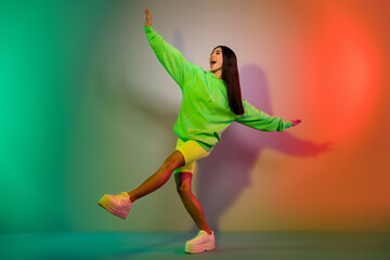 Full length body size view of attractive cheerful girl dancing resting isolated over multicolor vivid neon light background