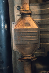 Vehicle underbody exhaust pipe, catalyst, resonator, exhaust system. Old parts require repair and replacement. Car service and maintenance. Standards and technical condition. vertical photo