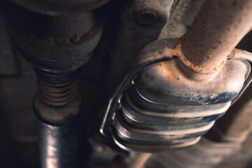 Vehicle underbody exhaust pipe, catalyst, resonator, exhaust system. Old parts require repair and replacement. Car service and maintenance. Standards and technical condition. selective focus - obrazy, fototapety, plakaty