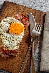 Close up of fried egg and bacon on whole wheat bread
