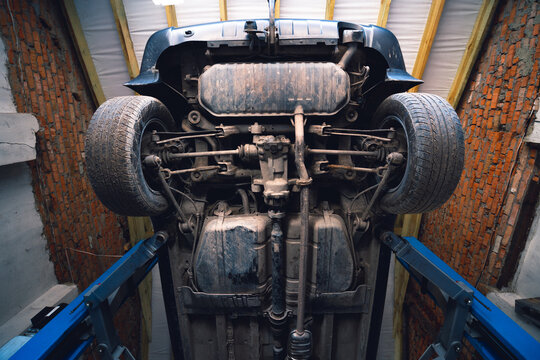 Car underbody front enginee wheels drives suspension of used car. service, exhaust system, catalytic converter, Gas tank, magnetic clutch for 4WD. cardan and differential