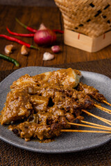 Pork Satay or Sate Babi. Pork Satay served with a Peanut sauce and slices of lontong or ketupat (rice cakes)