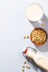 Vegan Soy milk and bean on gray table background. Non dairy milk concept. Diet drink. Hard light. Copy space