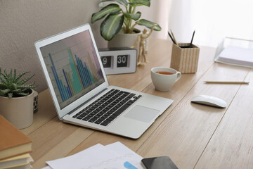 Stylish workplace with laptop on wooden desk. Interior design