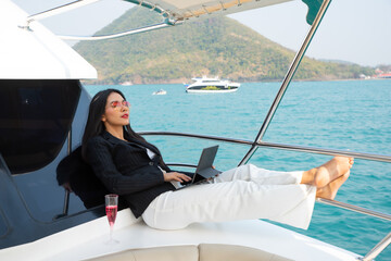 Asian young businesswoman with laptop at the yacht in summer