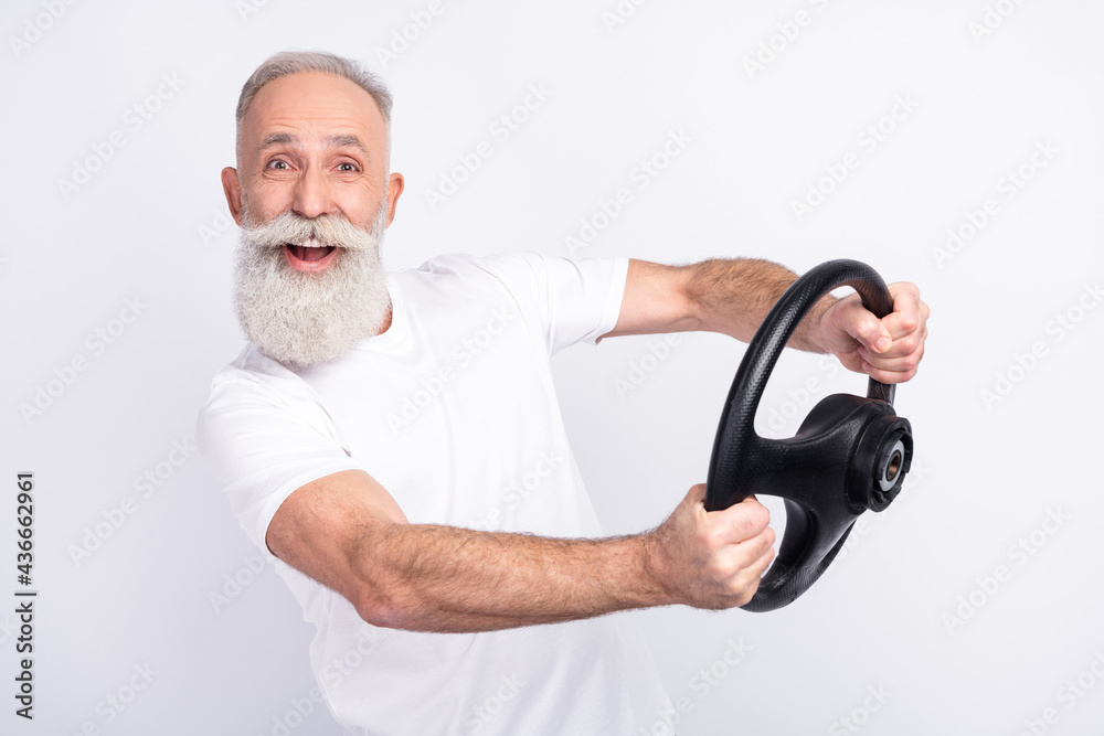 Wall mural photo of happy cheerful positive old man hold steering wheel smile rider isolated on grey color back