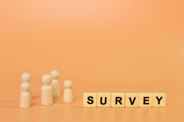 Wooden doll figures and alphabet letters with text SURVEY. Business concept.