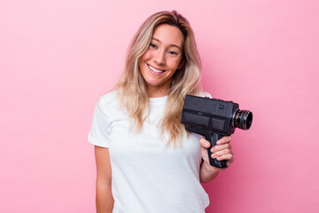 Young australian woman filming with a vintage video camera isolated happy, smiling and cheerful.