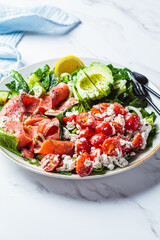 Fish salad with avocado, tomato, cucumber and onion. Keto diet recipe, Mediterranean cuisine.