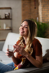 Girl holding a glass of water. Portrait of smiling girl drinking water