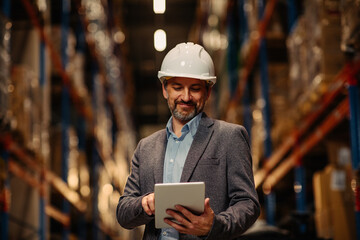 Young businessman in factory using digital tablet