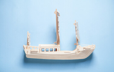 Wooden ship model on the blue background. Travel and Adventure