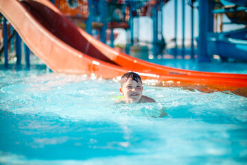 Happy little boy in pool at aqua park
