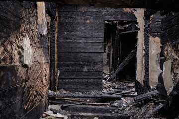 Dark burnt wooden house corridor after fire. Ruined house building after a fire