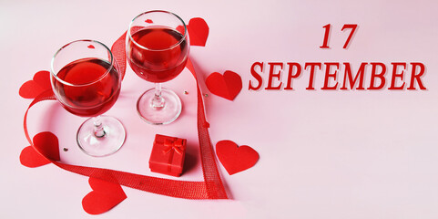 calendar date on light background with two glasses of red wine, red gift box and red hearts with...
