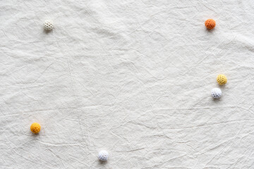 Off white textile flat lay with dry reeds, pampas grass and knitted cotton balls. Off white tablecloth background with copy space, place for text. Simple minimal flat lay, natural light, soft shadows.