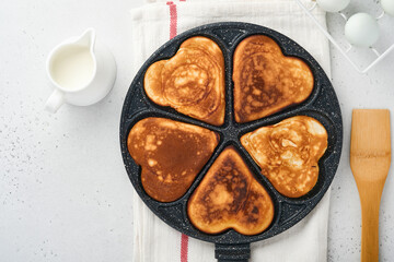 kes in shape of breakfast hearts in the frying pan with ingredients for cooking. Healthy breakfast or snack. Breakfast for Valentines Day.Top view copy space.