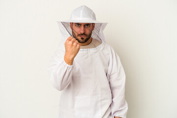 Young apiculture caucasian man isolated on white background showing fist to camera, aggressive facial expression.