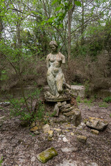 Becej, Serbia - May 01, 2021: The summer house of the noble family Gombos and a fountain in the shape of a bust of a young woman left to the ravages of time.