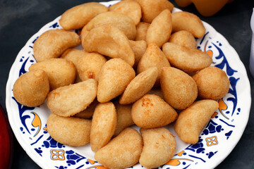 dish with savory snacks brazilian fried chicken balls and cream pastry