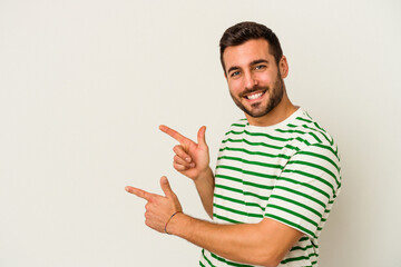 Young caucasian man isolated on white background excited pointing with forefingers away.