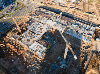 Tower cranes in action at construction site. Crane during formworks. Soil Compactor leveling ground...