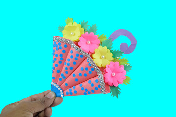 Blue and pink colored handmade crafted umbrella placed on a blue paper