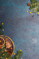 Beautiful Christmas background with decorations. Christmas cookies witch chocolate, gingerbread cookies, nuts and fir twigs on dark background. Copy space for your text