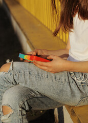 Girl holding a toy pop it. Anti stress hand toy. Push pop fidget toy.