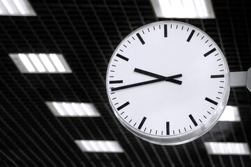 Close-up of a round electronic station clock. Black and white photography.