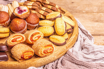 Assorted various cookies and muffins in wooden combination plate