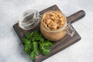 Homemade chicken liver pate in a glass jar on a gray concrete table. - obrazy, fototapety, plakaty