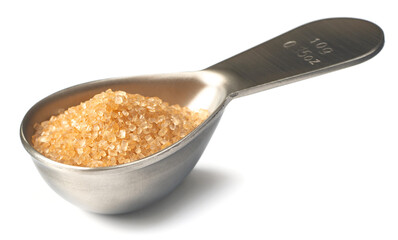 yellow sugar in the metal measuring spoon, isolated on white background
