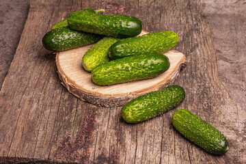 Crispy cucumbers on a wooden stand, marble background