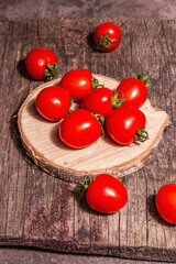 Red cherry tomatoes on a wooden stand