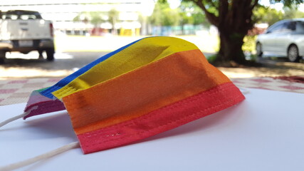 Yellow orange and red mask on a white sheet, a concept for pride month and encourage LGBTQIA communities around the globe.