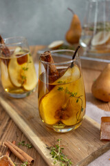 summer drink with a pear in a glass on a wooden background