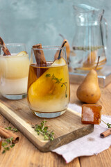 summer drink with a pear in a glass on a wooden background