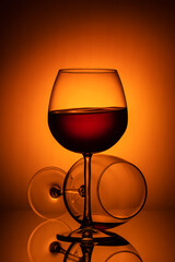 Still life, glass glasses with wine, on a background with a spot, and with a reflection
