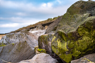 Fototapeta na wymiar Close up of rocks used to protect the Norfolk coastline with selective focus, shallow depth of field and bokeh