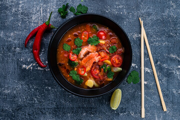 Delicious homemade fish and seafood soup with vegetables and tomatoes. Served in a round bowl.
