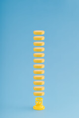 Creative minimalistic concept with fresh yellow banana slices as fizzy tablets on a bright blue pastel background. Modern health and vitamin idea, visual vertical arrangement.