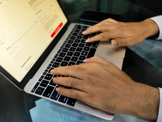 Naklejka premium fingers typing on laptop keys, closeup, black key board