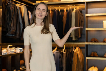 The saleswoman smiles and shows the clothes in the costume shop and speaks to the camera