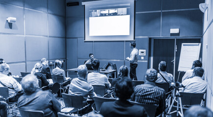 Business speaker giving talk at business conference event.